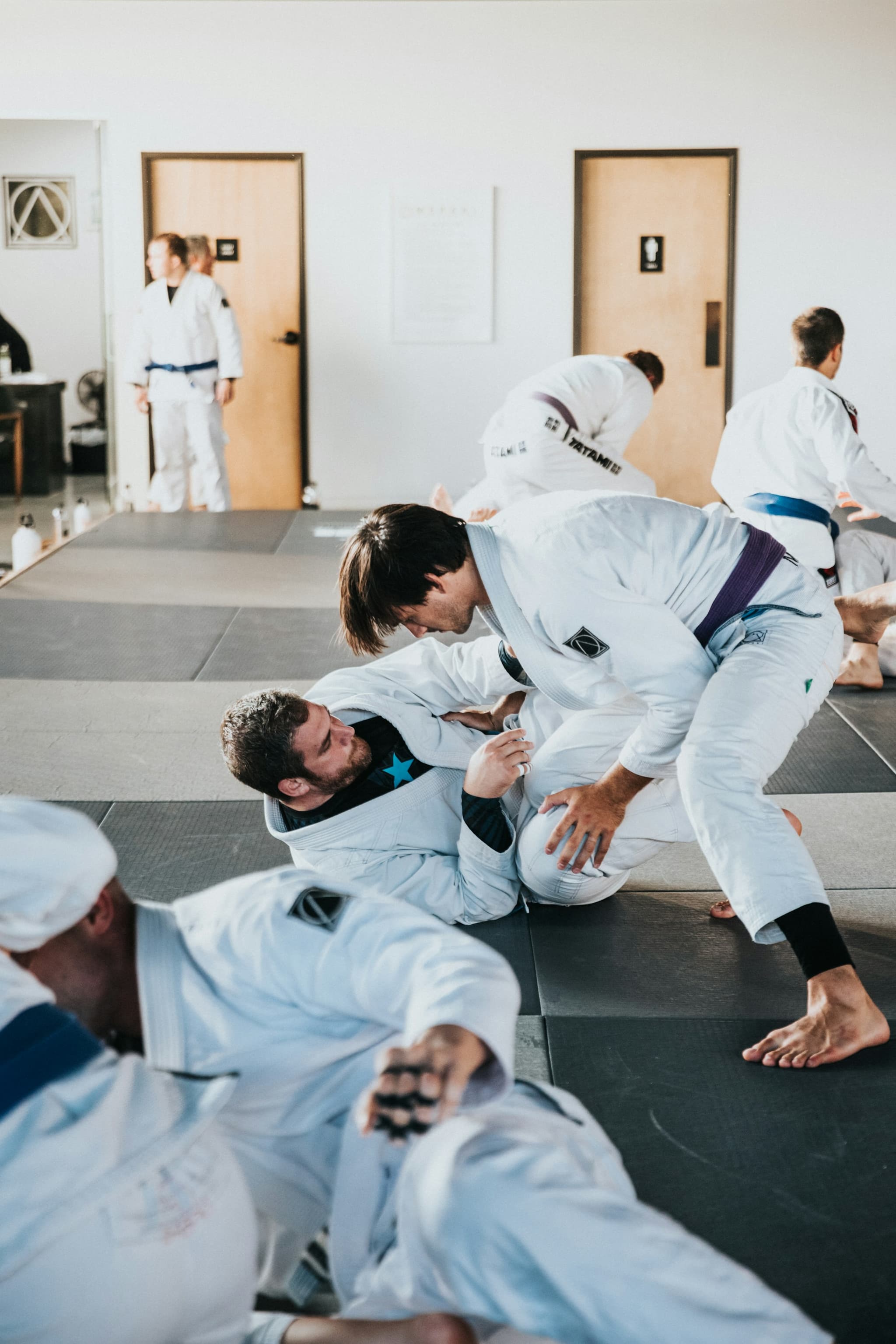 Brazilian Jiu-Jitsu athletes practising groundwork during a class